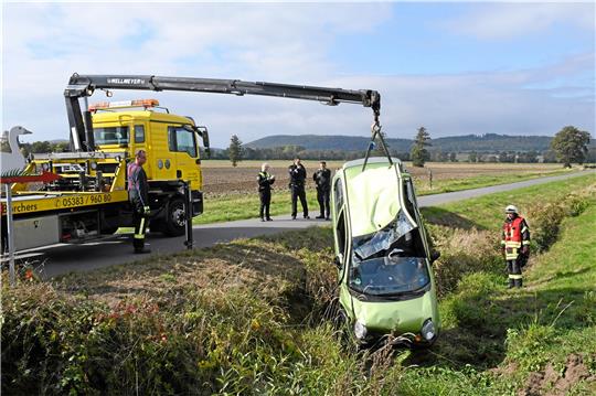 Nach dem Zusammenstoß landet die Unfallverursacherin mit ihrem Fahrzeug in dem angrenzenden Bach. Retter der Feuerwehr müssen sie aus dem Fahrzeug befreien, ehe es abgeschleppt werden kann. Fotos: Gereke