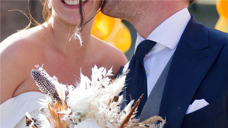 Nach der Hochzeit küsst Joe Laschet vor der Kirche seine Frau Andrea 