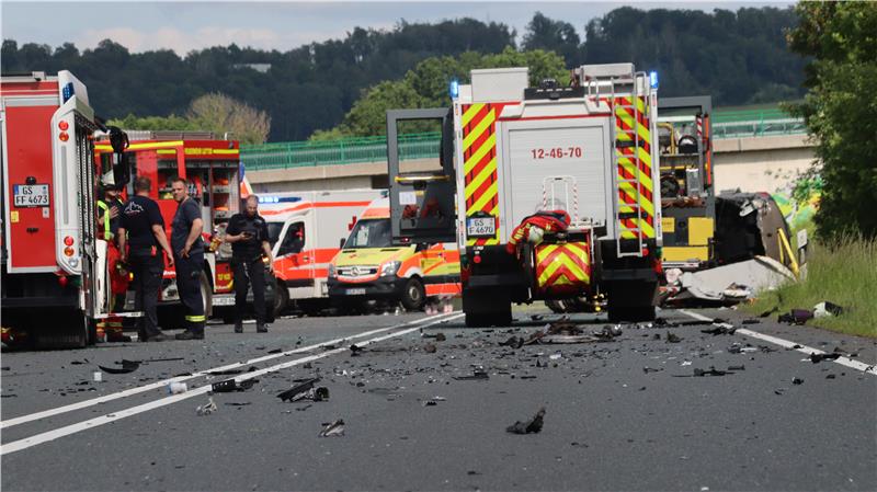 Viele Einsatzfahrzeuge von Feuerwehr und Rettungsdienst auf einer Straße. Im Vordergrund viele Trümmerteile.