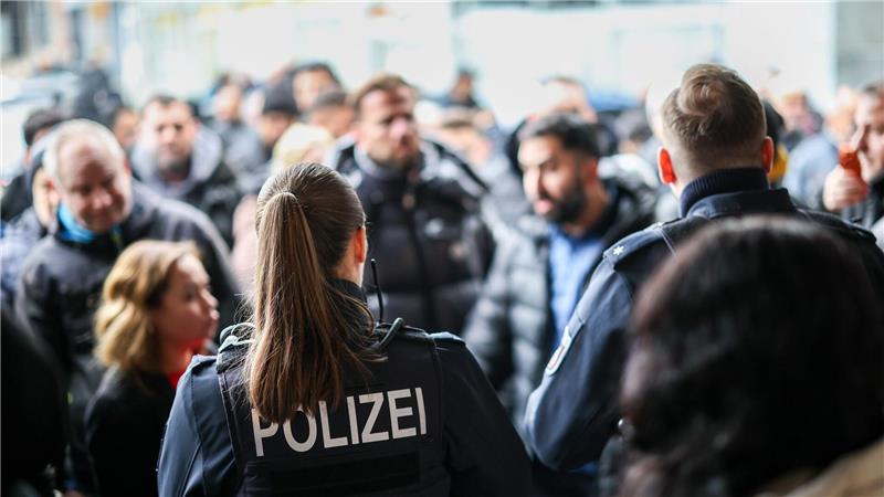 Nach der Räumung des Vorraums der Sparkassenfiliale sichern Polizeibeamte den Bereich vor der Sparkasse.