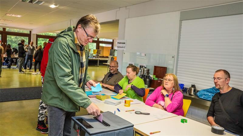 Mann an der Wahlurne.