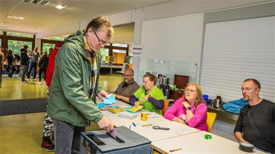 Mann an der Wahlurne.