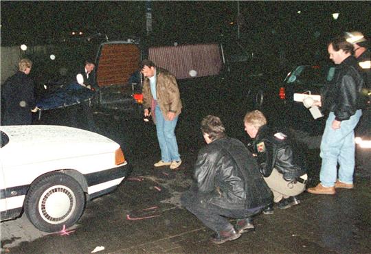Nach einem Familiendrama in Wolfsburg mit zwei erschossenen Toten und fünf Verletzten sichern Polizisten in Zivil und Uniform in der Nacht zum Montag (24.08.1998) Spuren, während im Hintergrund eine Leiche auf einer Bahre in einen Wagen geschoben wird. Foto: picture-alliance / dpa | Detlev_Waskow