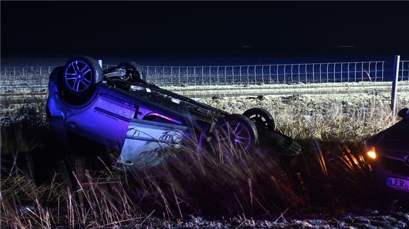 Nach einem Unfall bleibt ein Auto auf dem Dach liegen.