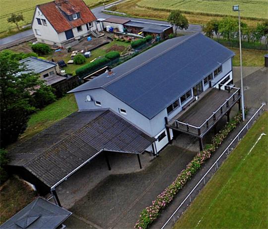 Luftaufnahme eines Gebäudekomplexes mit angrenzendem Fußballfeld