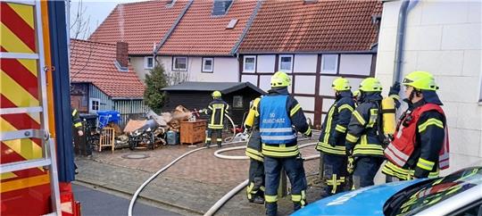Nachdem das Feuer gelöscht ist, tragen die Einsatzkräfte Möbel und Gerätschaften aus dem Schuppen. Foto: Feuerwehr Döhren