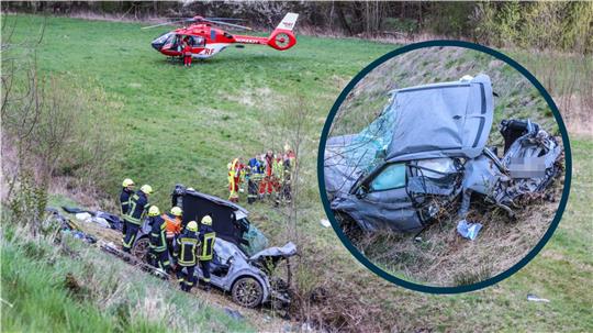 Der Kia steht nach dem Unfall an der 30 Meter tiefen Böschung. Ein Rettungshubschrauber im Hintergrund.