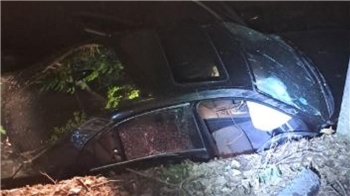 Ein verunfalltes Auto in einem Flussbett.