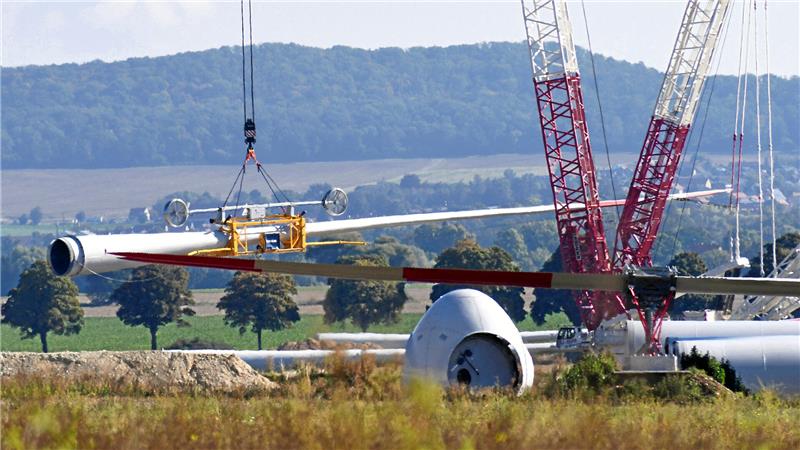 Nachdem mehrere Tage der Wind blies, herrschen nun die passenden Bedingungen, um die Vollerrichtung der Anlagen fortzusetzen – ein Rotorblatt hebt ab.