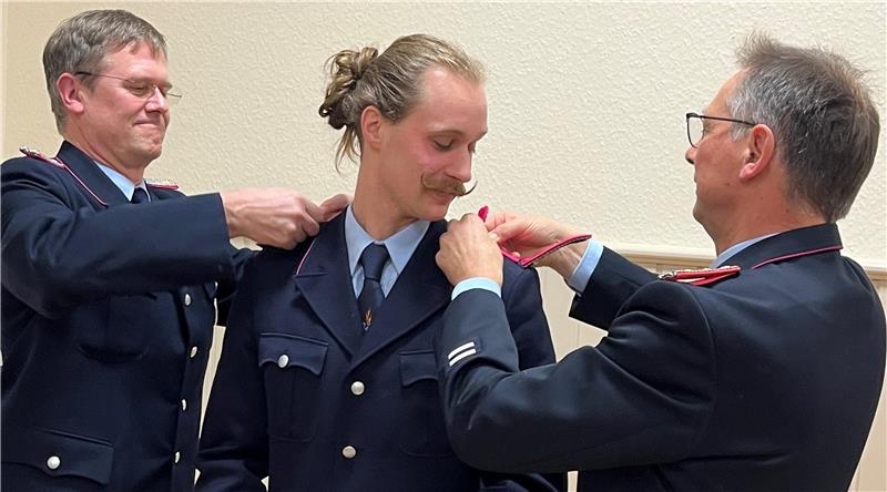 Nauens Ortsbrandmeister Jeldrik Quint erhält von seinem Stellvertreter Stefan Bergmann (l.) und dem stellvertretenden Stadtbrandmeister Hartmut Ölmann neue Schulterstücke – er trägt jetzt den Dienstgrad Löschmeister.