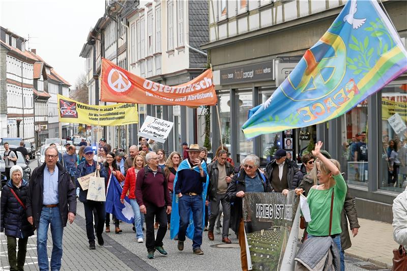 Neben bedruckten Fahnen, Bannern und T-Shirts gibt es handbemalte Schilder („Frieden und Gerechtigkeit für alle Menschen“) und andere Accessoires für den Frieden: Der bunte Ostermarsch vom Friedensbündnis Goslar geht am Ostersamstag mit Symbolen wie Peace-Zeichen und Friedenstauben auch die Breite Straße hinauf. Foto: Epping