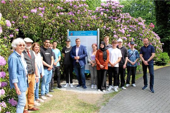 Neben den HRS-Schülerinnen und -Schülern weihen unter anderem Kirchenvorstandsvorsitzende Dorothee Austen (links), Bildungsreferent Dr. Rainer Bendick (zweiter von links), Landrat Dr. Alexander Saipa (Mitte) und HRS-Lehrer Hendrik Gattermann (rechts) die Erinnerungstafel auf dem Friedhof ein. Foto: Wendt