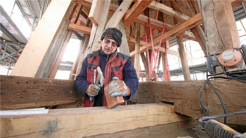 Neben den Zimmerleuten sind derzeit auch die Maurer an der Turmspitze am Werk.