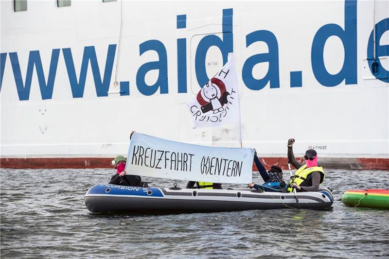 Kreuzfahrtschiff startet nach Klima-Blockade mit Verspätung Neben der «Aida Diva» halten Klimaaktivisten ein Transparent mit der Aufschrift «Kreuzfahrt (K)entern».