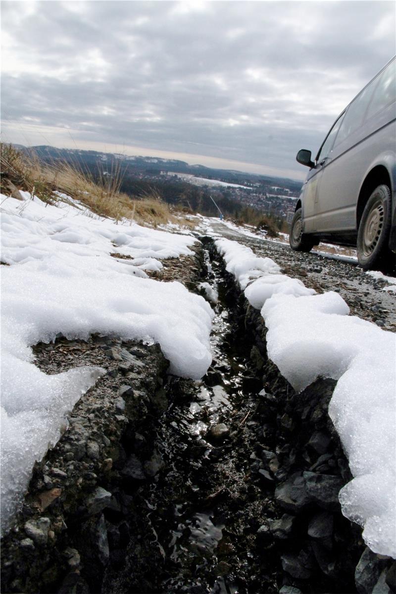 Neben der Straße, die zwischen Mittelstation und Tal liegt, hat das Wasser tiefe Furchen gebildet. Die Piste an der Bergstation (r.) ist nicht mehr umsäumt von Fichten wie früher, Stürme haben leichtes Spiel. Fotos: Potthast