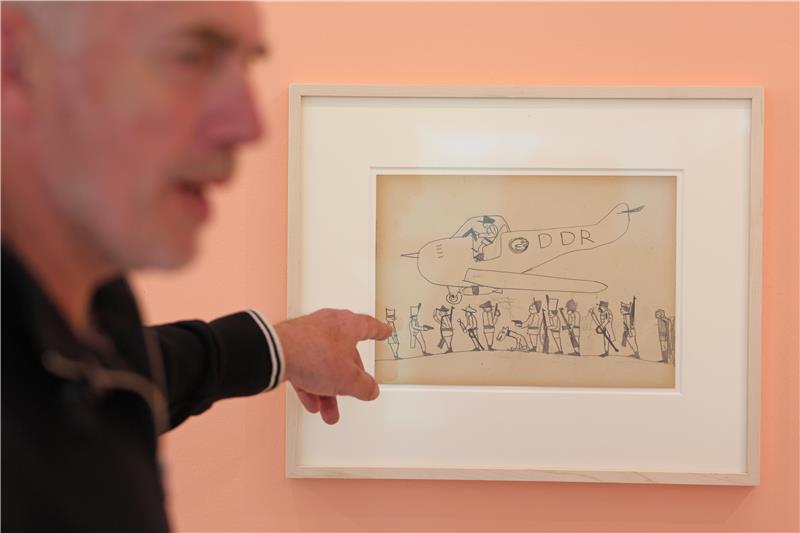 Neo Rauch zeigt in der "Grafikstiftung Neo Rauch" in Aschersleben auf eine seiner Zeichnungen, die er als Kind gemalt hat.