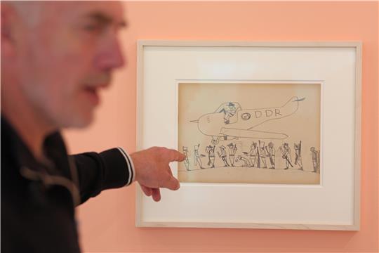 Neo Rauch zeigt in der "Grafikstiftung Neo Rauch" in Aschersleben auf eine seiner Zeichnungen, die er als Kind gemalt hat.