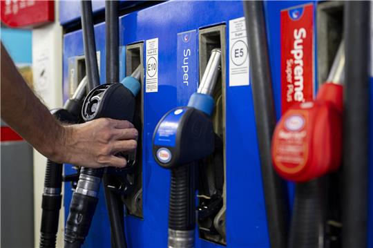 Eine Hand greift nach einer Zapfpistole.