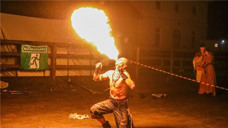 Ein Mann spuckt Feuer.