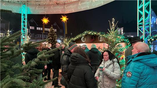 Das Foto zeigt Besucher einen Marktes, die friedlich zusammenstehen.