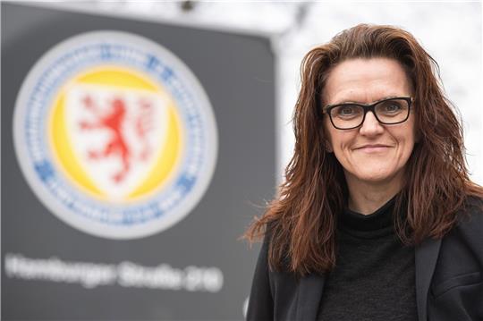 Nicole Kumpis steht vor dem Logo von Eintracht Braunschweig.
