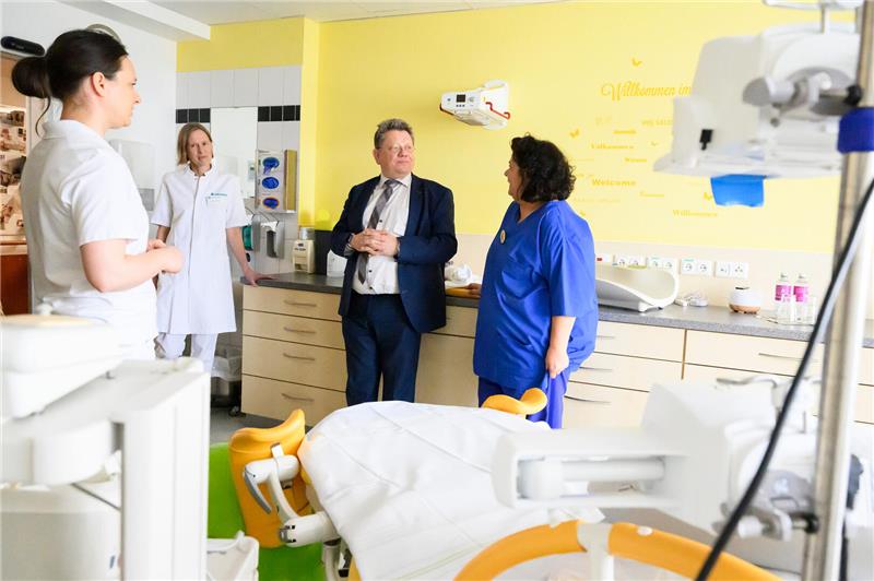 Ein Mann spricht in einem Kreißsaal mit einer Frau.