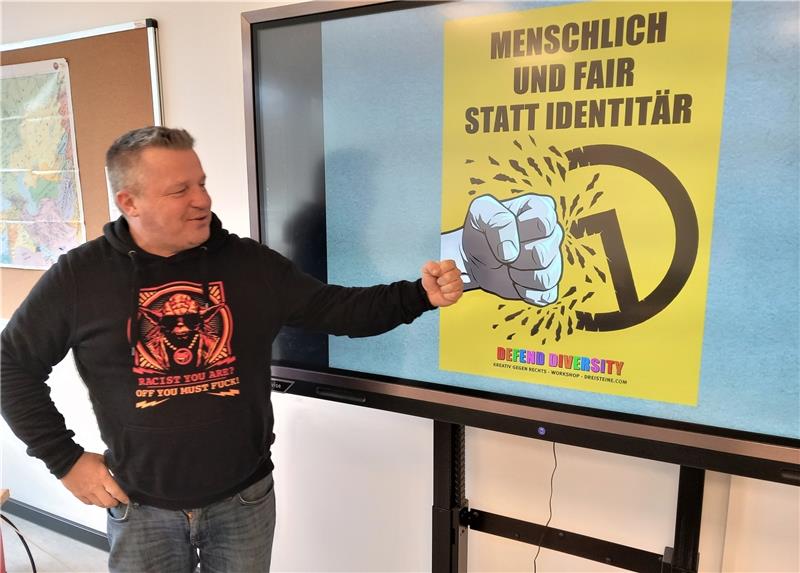 Liebenburger Schüler entwerfen Cartoons Nils Oskamp vor einem seiner Plakate gegen die Identitäre Bewegung, die den Staat und die Demokratie in Frage stellt.