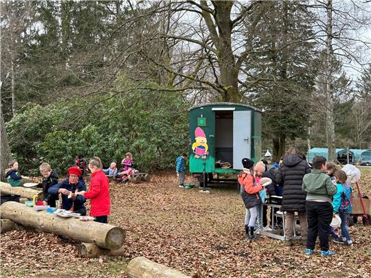 „Nix wie raus“ ist das Motto der Betreuung während der Osterferien. Die Gruppe, um die sich erstmals auch Initiatorin Cornelia Ehrhardt (dritte von rechts) kümmert, hält sich unter anderem am Bauwagen des Kindergartens im Kurpark auf. Foto: Eggers