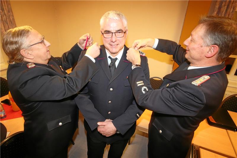 Noch-Wehrchef Bernhard Neumann (li.) und der stellvertretende Stadtbrandmeister Hartmut Ölmann (re.) statten Neuwallmodens designierten Ortsbrandmeister Ralf Köppelmann mit neuen Schulterstücken aus. Foto: Gereke