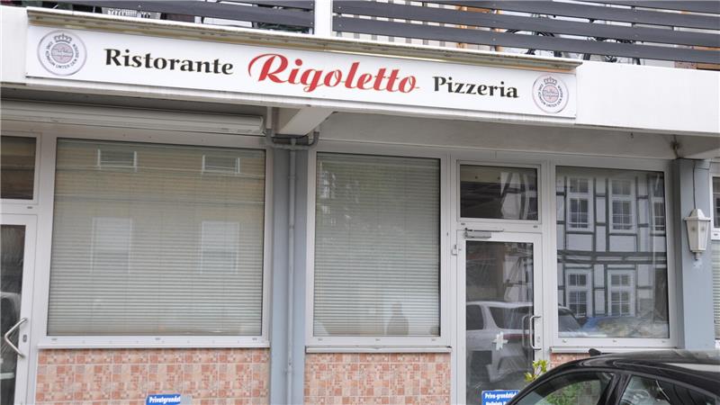 Fassade eines Restaurants mit dem Schriftzug 'Ristorante Rigoletto Pizzeria' über geschlossenen Fenstern und einer geparkten schwarzen Autotür im Vordergrund