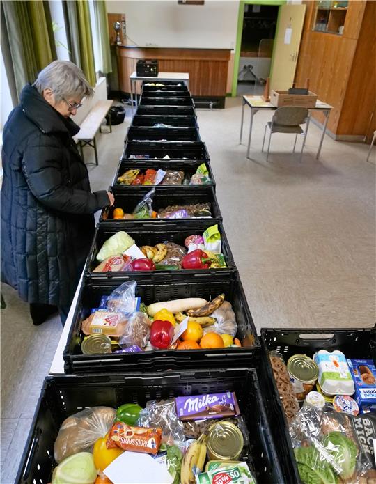 Noch vor 8 Uhr werden die Lebensmittel-Kisten für die Bad Harzburger Tafel-Kunden per Pkw vom Tafel-Hauptsitz Oker geliefert. Im Saal gleich rechts hinter der Eingangstür des St.-Gregor-Heims stehen sie bereit. Ehrenamtliche Helfer und Helferinnen, wie Marlis Illlies, geben sie aus. Fotos: Potthast