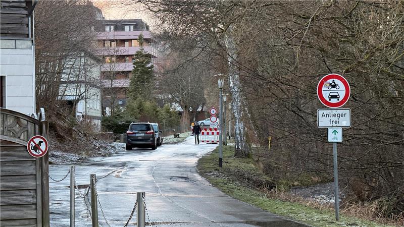 Das Foto zeigt eine schmale Straße, die im hinteren Bereich gesperrt ist.