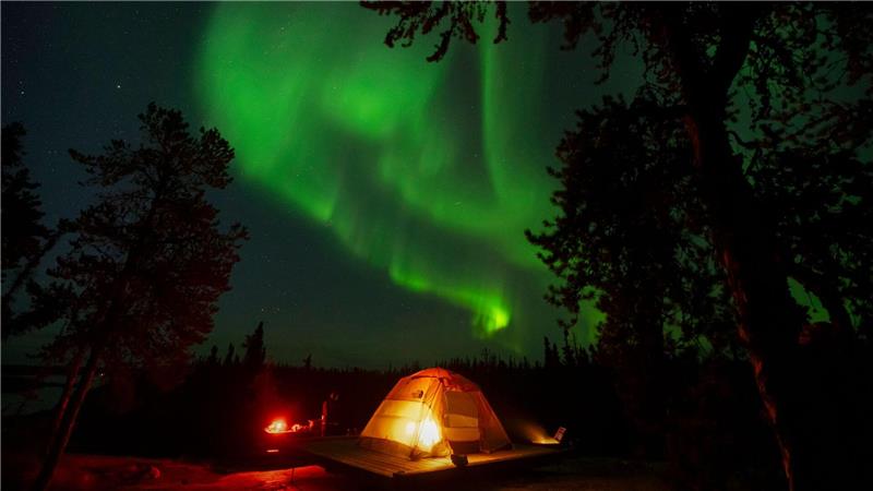 Nordlichter, auch bekannt als Aurora Borealis, sind am frühen Morgen am Himmel über einem Zelt in der Nähe von Yellowknife in Kanada zu sehen.