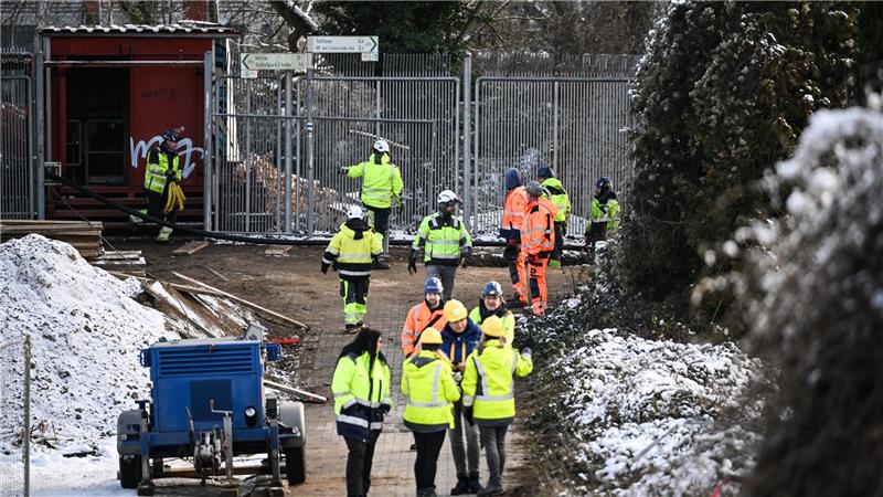 Das Foto zeigt 14 Bauarbeiter vor der Kabelbrücke in Berlin bei der Notreparatur.