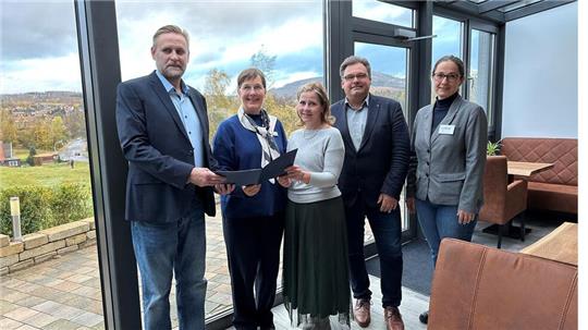 November 2023: Landesbeauftragte Dr. Ulrike Witt (2.v.l.) überreicht einen Förderbescheid an Marc Kühne (l.) und seine Frau Beatrice (Mitte) im neuen Wintergarten des Hotels Brunnenbach in Braunlage. Edda Schaper von der Wirego und Bürgermeister Wolfgang Langer freuen sich ebenfalls. Die Hotelbetreiber haben 850.000 Euro investiert und 60.000 Euro Fördergeld erhalten.