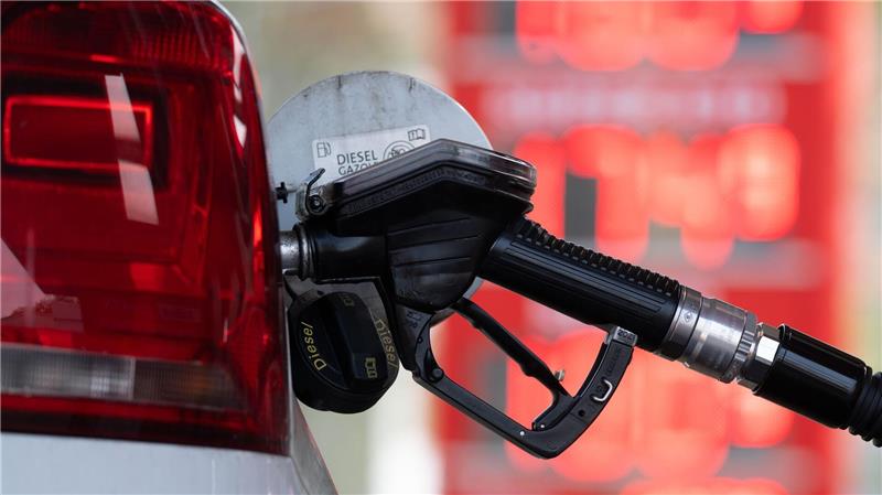 Das Foto zeigt einen Zapfschlauch, der an der Tanköffnung in einem Auto steckt.