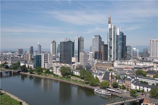 Nur wenige Wolken ziehen über den Himmel über der Bankenskyline von Frankfurt und den Main hinweg.