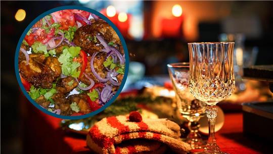 Das Bild zeigt einen gedeckten Tisch und ein kleines Foto mit angerichtetem Essen. 