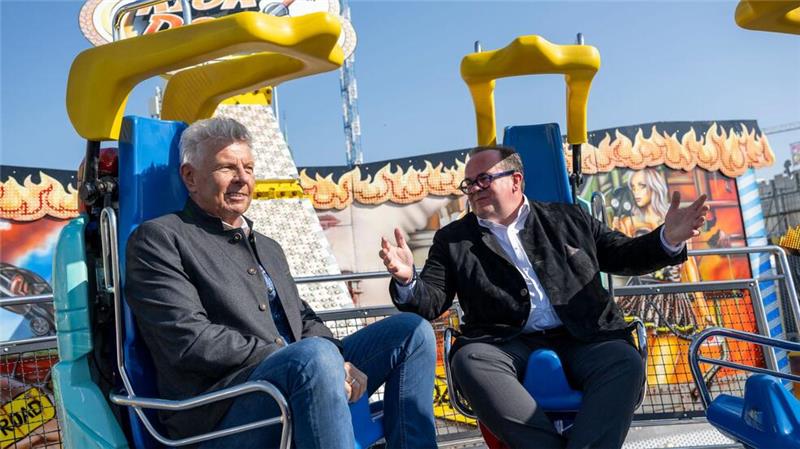 Wiesn startet - Fans reisen nach München Oberbürgermeister und Festleiter testen vor dem Start ein Fahrgeschäft.