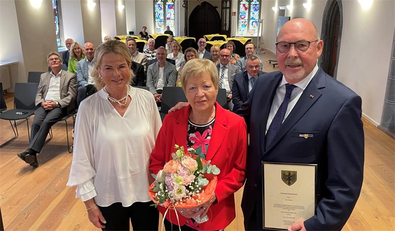 Das Foto zeigt von links Oberbürgermeisterin Urte Schwerdtner, Barbara Hulsch mit Blumenstrauß und Eike Hulsch mit einer Urkunde der Stadt.