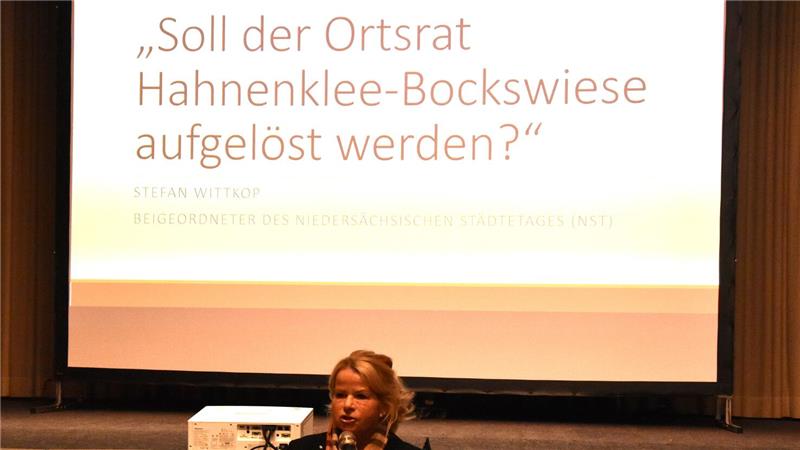 Person steht vor einer Leinwand mit der Projektion des Texts 'Soll der Ortsrat Hahnenklee-Bockswiese aufgelöst werden?'