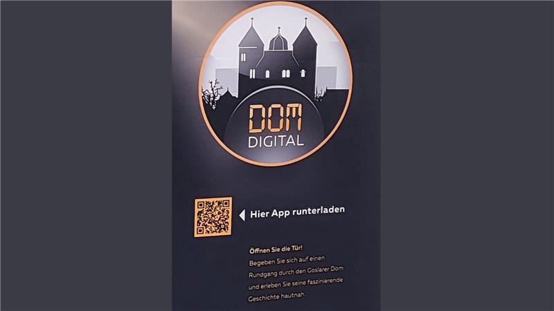Ein Plakat mit QR-Code weist auf die neue App "Dom:Digital" hin