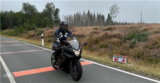 Das Foto zeigt einen Motorradfahrer, der über einen Rüttenstreifen fährt.