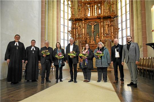 Oft haben in der Vergangenheit Pfarrerinnen und Pfarrer sowie Kita-Leitungen die immer komplexer werdenden Aufgaben von Kita-Trägern übernommen. Stellvertretend gibt es als Dank Blumen für (mit Blumen v.li.) Dirk Glufke, Karin Liebl, Ulrich Müller-Pontow, Kathrin Reich und Melanie Grauer. Den Einsegnungsgottesdienst gestalteten Thomas Gunkel (li.) und Peter Kapp (2.v.li.). Die Träger-Arbeit übernehmen (v.re.) Florian Bergmann und Andreas Duglos. Fotos: Kempfer