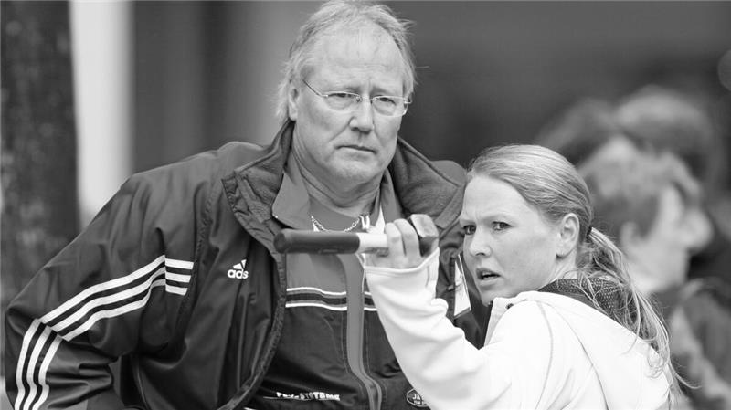 Zwei Personen, eine mit Adidas-Jacke, die andere mit Kapuzenpullover, stehen nah beieinander