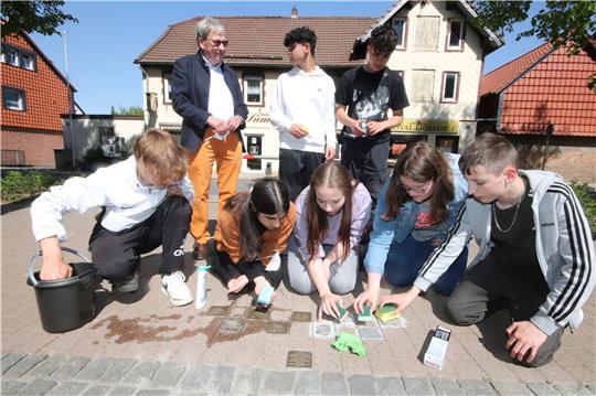 Okeraner Adolf-Grimme-Gesamtschüler reinigen die Stolpersteine und bringen sie wieder auf Hochglanz. Im Hintergrund unterhält sich Dr. Kurt Fontheim mit zwei weiteren Jugendlichen aus dem Wahlpflichtkursus.  Fotos: Gereke
