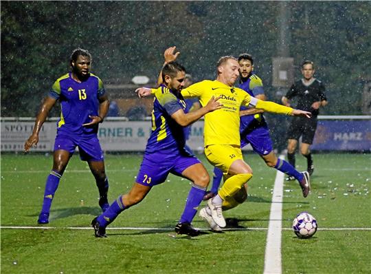 Okers Spielertrainer Mehmet-Ali Tozlu (2. v. l.) und der Rammelsberger Marcel Sollorz gehen auf dem rutschigen Kunstrasen auf Balljagd. Am Ende siegt der VfL mit 5:2. Foto: Epping