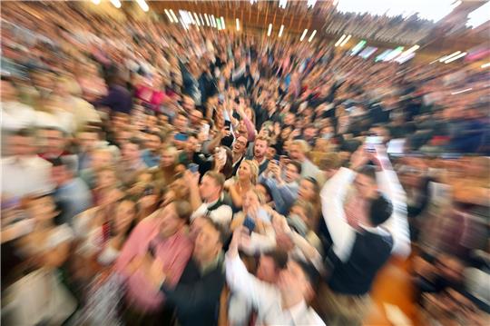Oktoberfestbesucher in einem voll besetzten Festzelt.