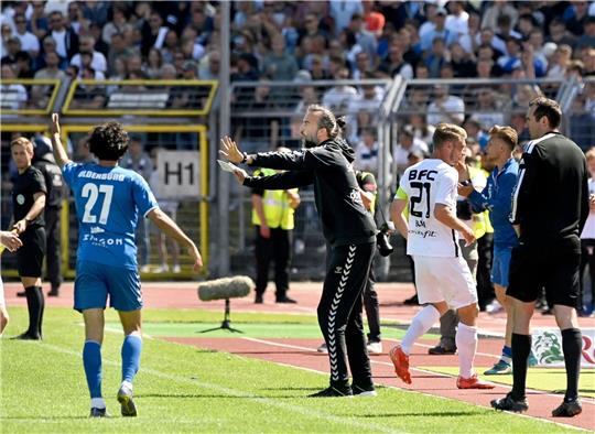 Oldenburgs Trainer Dario Fossi (M) gibt Anweisungen am Spielfeldrand.