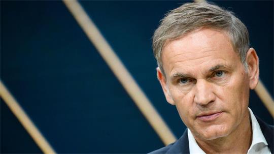 Mann mit weißem Hemd und kurzem Haar.